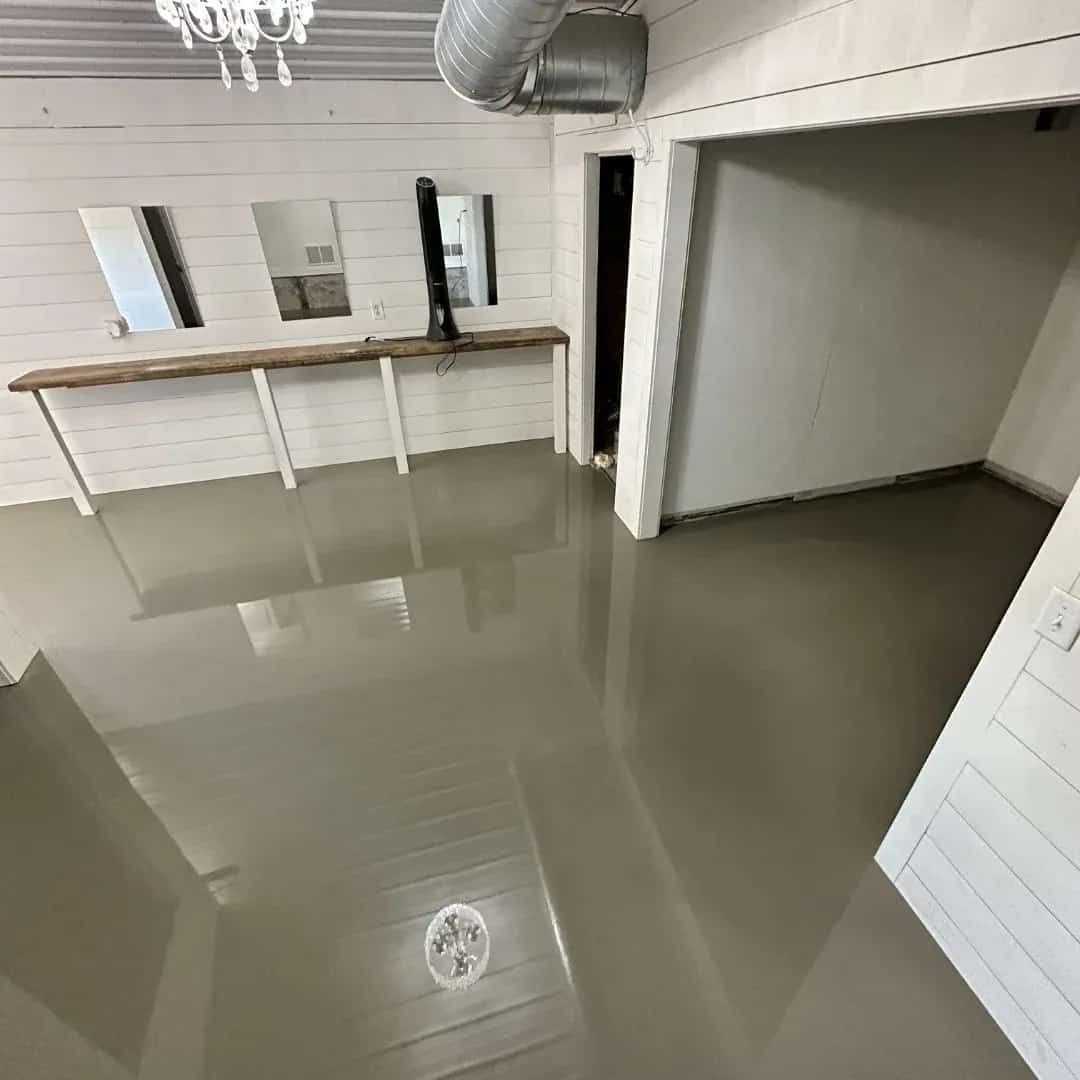 Fresh self leveling concrete placed across an uneven interior floor in West Michigan