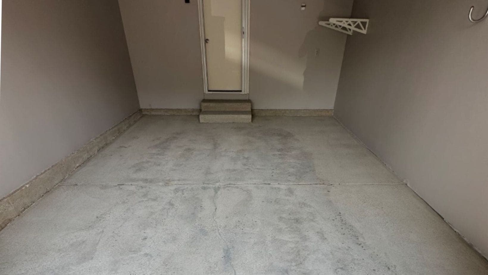 Bare basement concrete before coating in a Comstock Park style ranch home