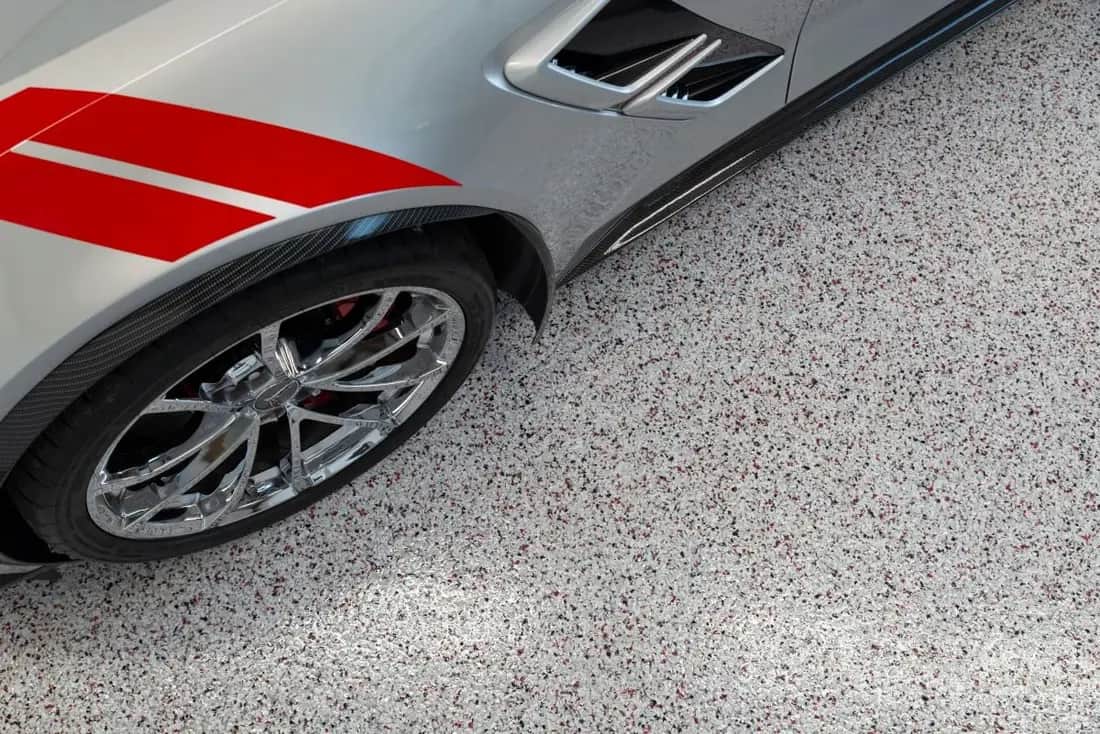 Decorative garage floor coating in use beneath a vehicle
