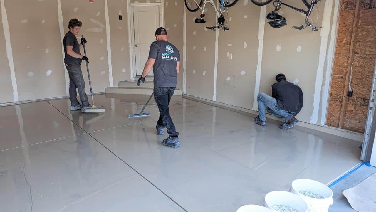 Crew applying a coating base layer to concrete