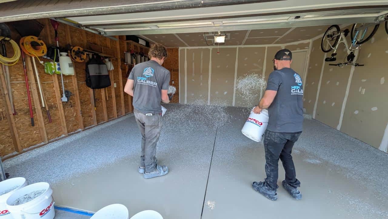 High Caliber crew broadcasting decorative flake over a wet garage floor