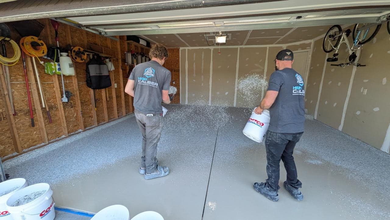 High Caliber crew broadcasting decorative flake over a wet garage floor