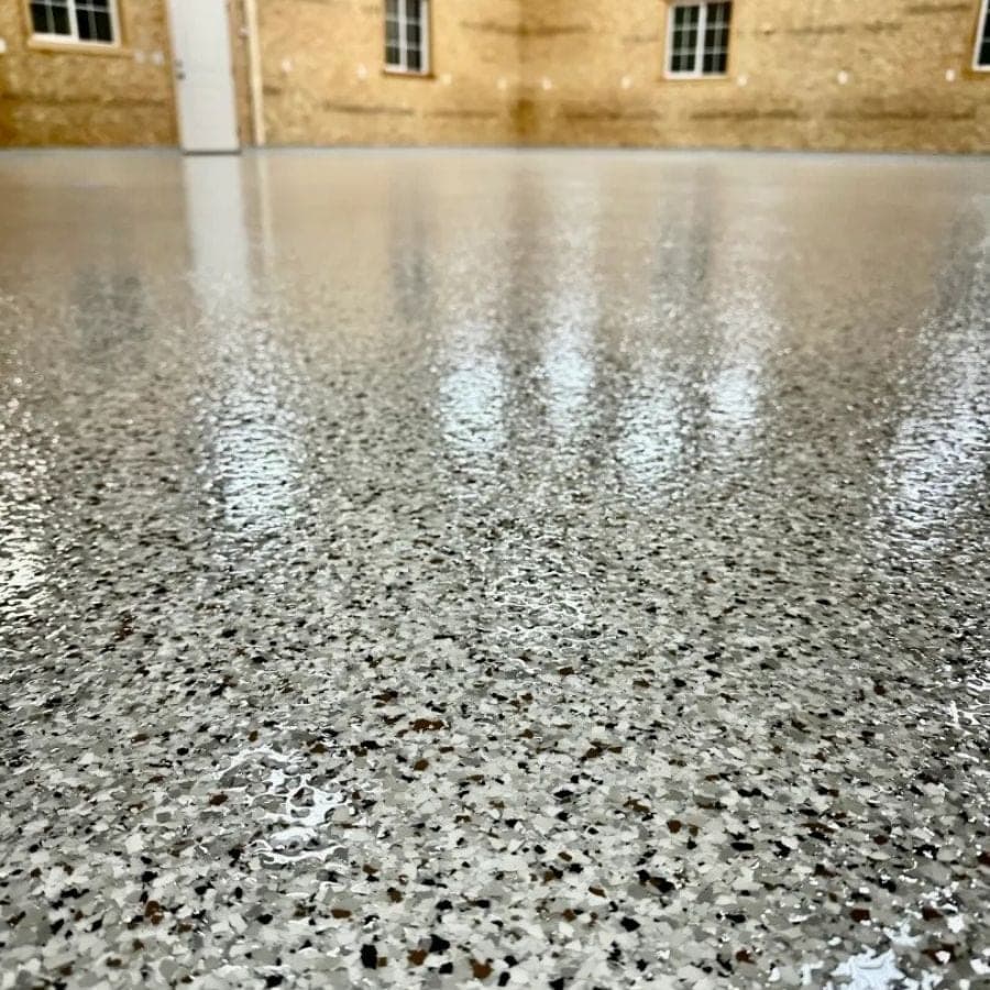 Installer applying a UV-stable polyaspartic topcoat to a West Michigan floor